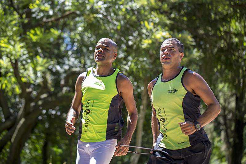 Dois homens aparecem na foto. Alexandre está à esquerda, correndo junto com o seu treinados Eduardo Peres. 