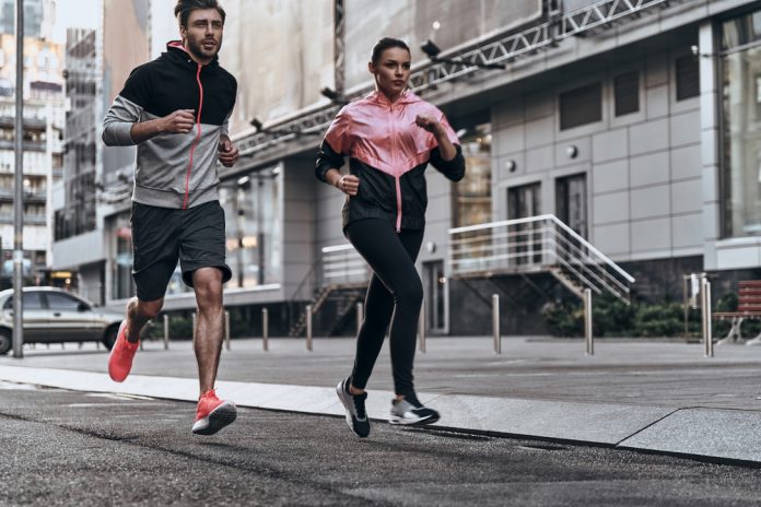 sintomas de infarto súbito em corredores - imagem mostra um homem e uma mulher correndo na rua